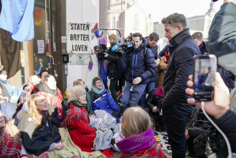 Her snakker olje- og energiminister Terje Aasland med aksjonister fra Natur og ungdom og Norske Samers Riksforbund Nuorat mens de blokkerte inngangene til Olje- og energidepartementet tirsdag. Bakgrunn for aksjonen er at vindturbinene på Fosen, som Høyesterett har sagt er ulovlige, ikke er revet. Her snakker olje- og energiminister Terje Aasland med aksjonister fra Natur og ungdom og Norske Samers Riksforbund Nuorat mens de blokkerte inngangene til Olje- og energidepartementet tirsdag. Bakgrunn for aksjonen er at vindturbinene på Fosen, som Høyesterett har sagt er ulovlige, ikke er revet. Foto: Stian Lysberg Solum / NTB