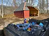 FORSØPLING OG SKADER. Her ligger det både knuste flasker, russekort og tomme bokser. I følge Helena som stadig går tur hit, er også det lille grillhuset i bakgrunnen nylig skadet.