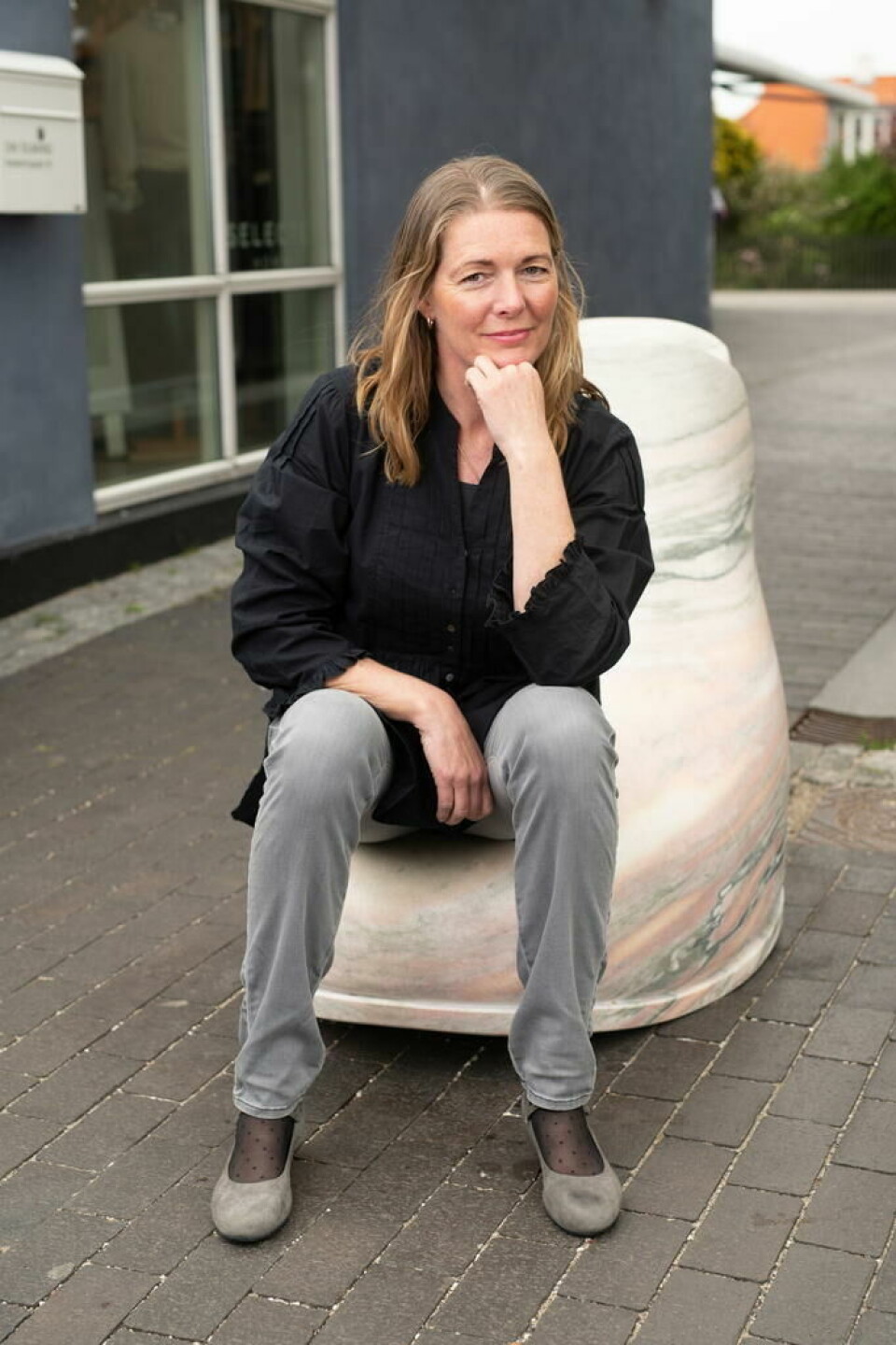 PÅ MARMOR. Her sitter den nye eieren av bruddet i Løgavlen, Susan Moser på en kjempesko av fauskemarmor, som står i Gilleleje i Danmark. PÅ MARMOR. Her sitter den nye eieren av bruddet i Løgavlen, Susan Moser på en kjempesko av fauskemarmor, som står i Gilleleje i Danmark. Foto: Privat