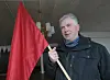 RØDT. 1. mai-høvdingen Kjell Basse Lund tar et godt tak rundt det røde flagget og følger oppfordringen til avdøde Dag Skogheim om å flagge på 13. januar til minne om 1907. Oppfordringen går ut på å flagge med det norske flagget. Foto: Arild Bjørnbakk