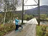 NÆRT, MEN FJERNT. Innlandet bru, som nå er stengt for motorisert ferdsel. Oddbjørg peker over mot der sønnen hennes bor. Foto: Jan Håkonsen