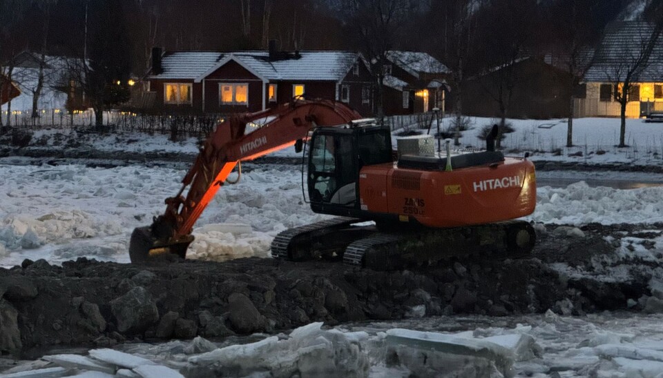 GRAVER. Flere maskiner er i sving for å ta unna ismassene i elva.