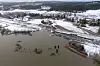 Dronebilde av rasområde ved innsjø, med ødelagt vei og jernbanespor omgitt av snødekt landskap.
