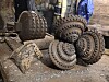 Slitte metallborehoder ligger samlet på bakken i et steinete industriområde.