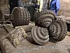 Slitte metallborehoder ligger samlet på bakken i et steinete industriområde.